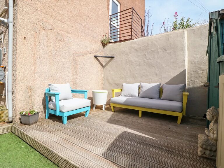 Private enclosed back garden with decking and outdoor seating at the 3-Bed Garden Apartment